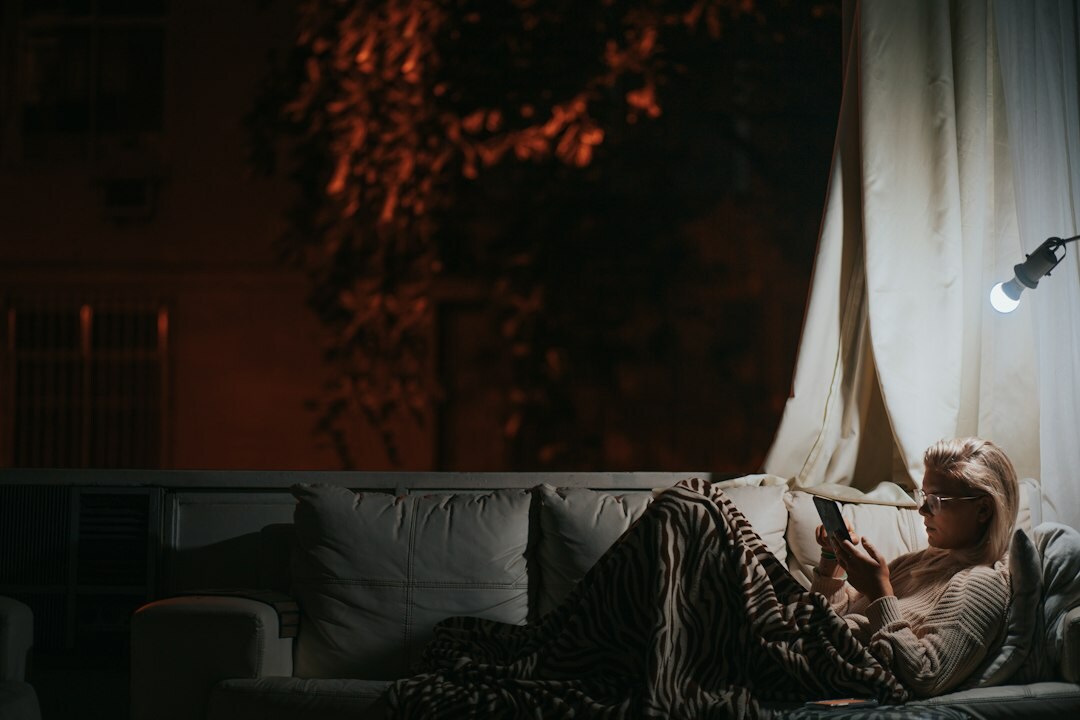 Person relaxing on a couch reading news on a tablet